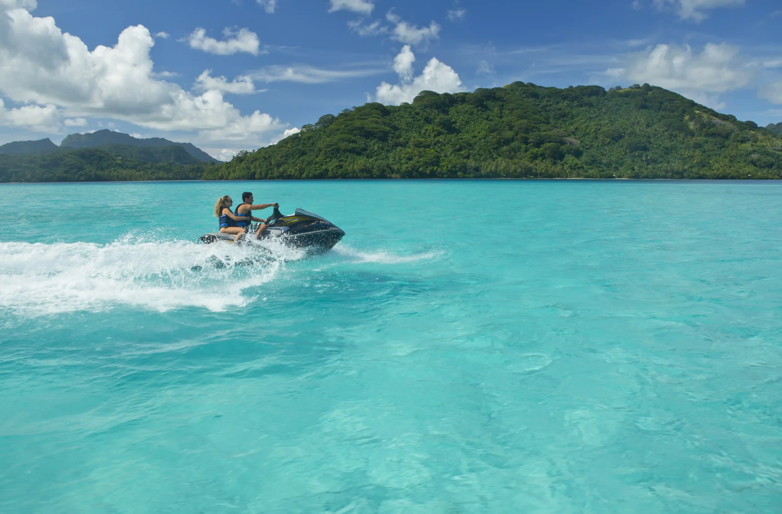 Two people riding water motor bike at Huahine, Tahiti